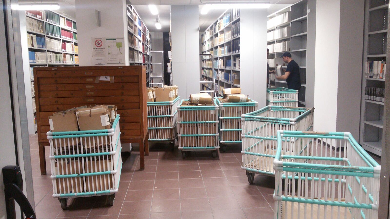 Sala 82 - Nuovo Deposito librario con ceste di libri e riviste